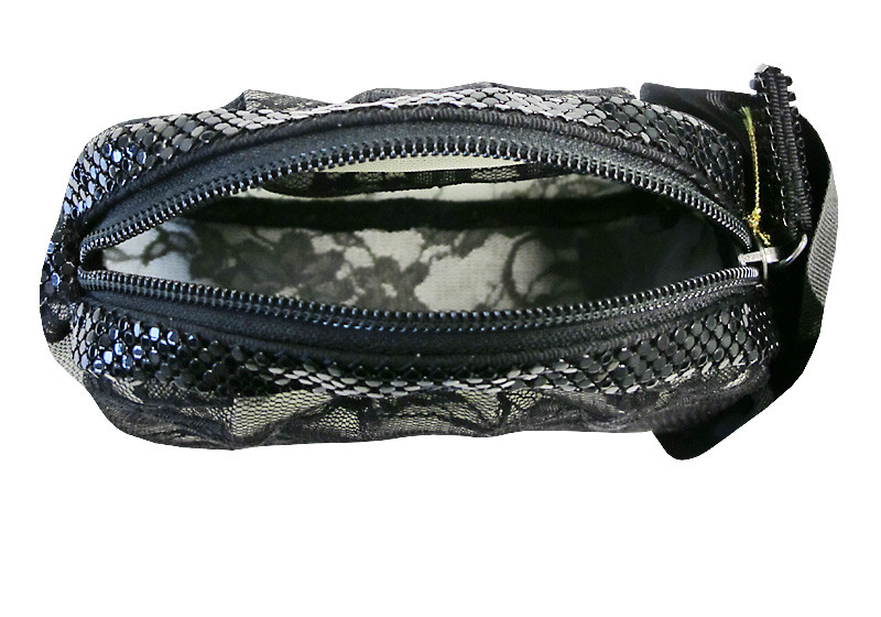 Der Reißverschluss wird von schwarzen Strasssteinchen umrahmt Der Reißverschluss wird von schwarzen Strasssteinchen umrahmt