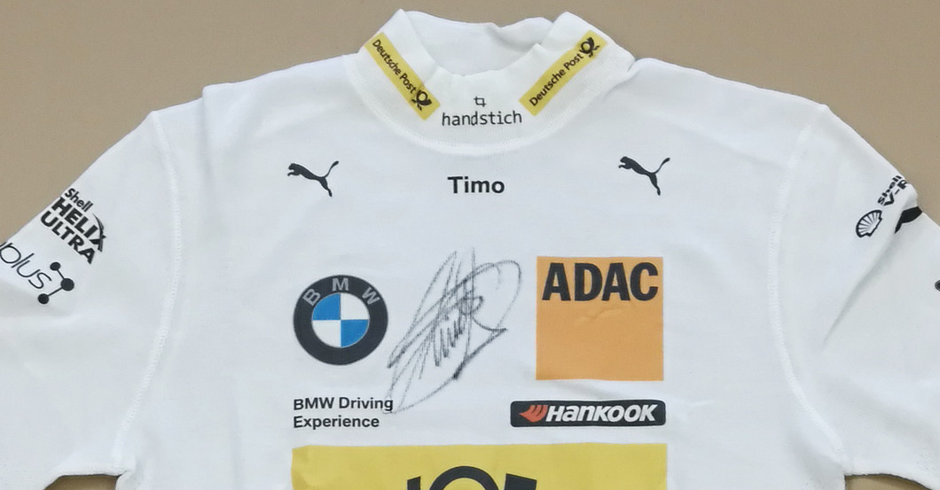 DTM-Star Timo Glock signiert sein Original Rennhemd